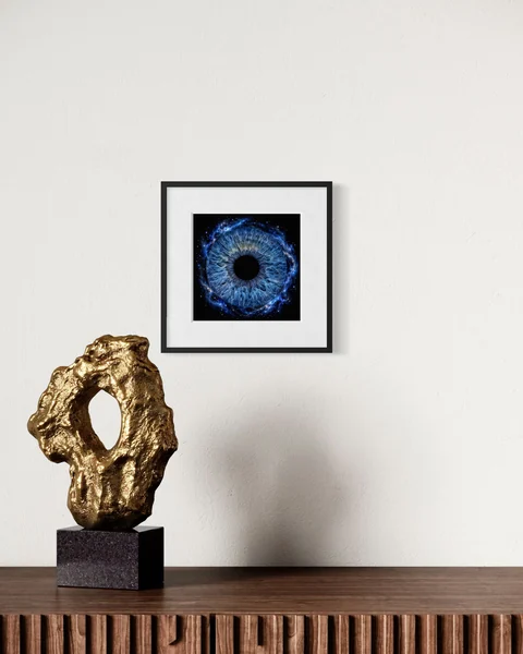 Raumvisualisierung: Blaue Iris im schwarzen Rahmen über einer Holzkommode mit goldfarbener Skulptur