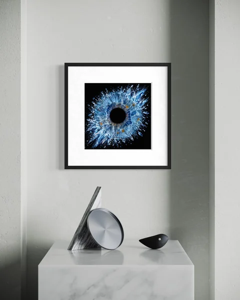 Raumvisualisierung: Blaue Iris im schwarzen Rahmen über einer grauen Konsole mit geometrischer Skulptur